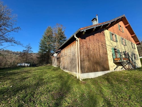 Chalet rustique en bois du Repaire Des Darous B&B à Saulxures sur Moselotte, pelouse verte et forêt en arrière-plan