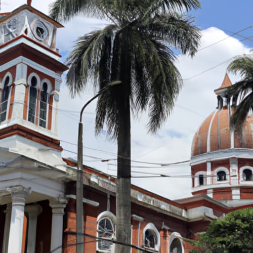 Arquitectura colonial del Hotel Maderos Cali con ladrillos rojos, detalles blancos, techo de cúpula y palmera en Cali, Colombia
