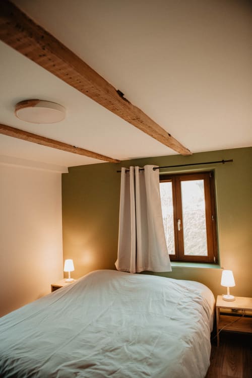 Chambre cosy du gîte THE REPAIRE à Repaire Des Darous, Saulxures sur Moselotte, avec poutres apparentes et murs olive