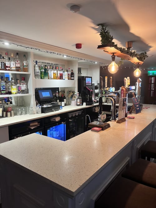 Modern bar counter at The Railway Hotel Haydon Bridge with spirits display, beer taps, and ambient lighting