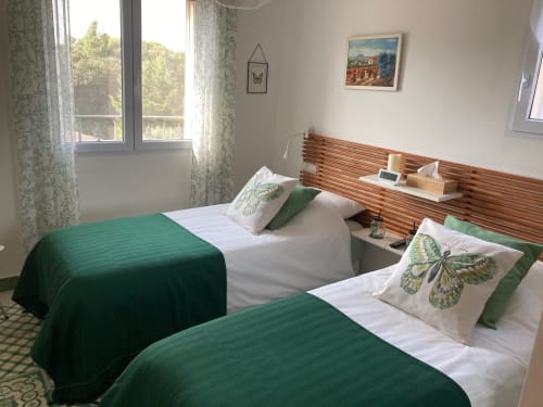 Twin bedroom with green blankets and butterfly pillows at Domaine des Lavarines cottage in Avignon, France