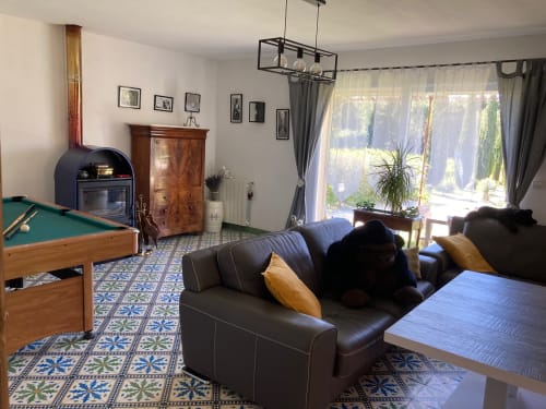 Spacious cottage living area with pool table, black leather seating, fireplace, and garden views at Domaine des Lavarines