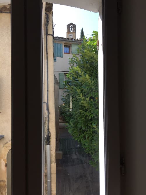 View from VIP Lodge apartment at AJOUCADOU in Lourmarin showing charming French village buildings and clock tower
