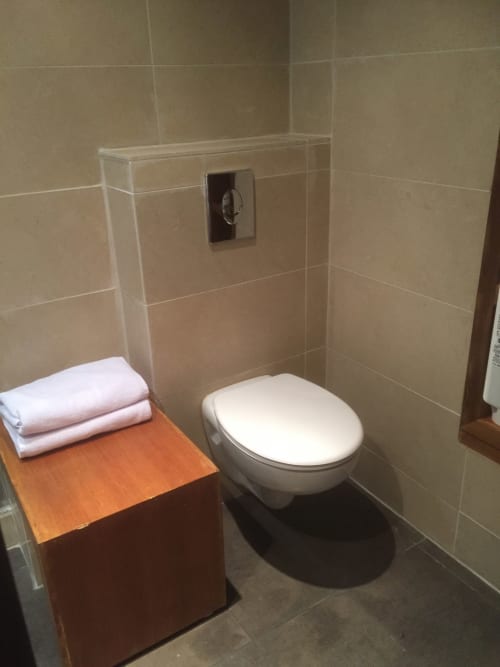 Modern bathroom in VIP Lodge apartment at AJOUCADOU hotel in Lourmarin with wall-mounted toilet and towel storage