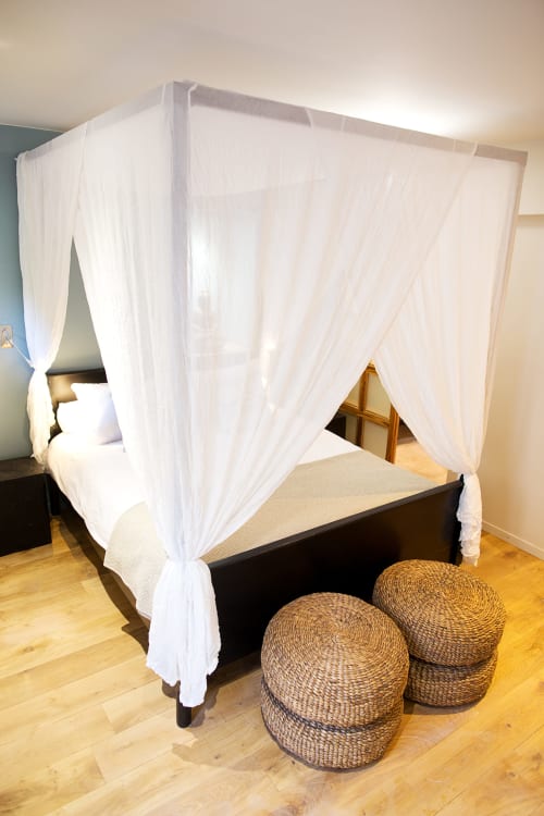 Elegant four-poster canopy bed with white sheer curtains in AJOUCADOU VIP Lodge, Lourmarin