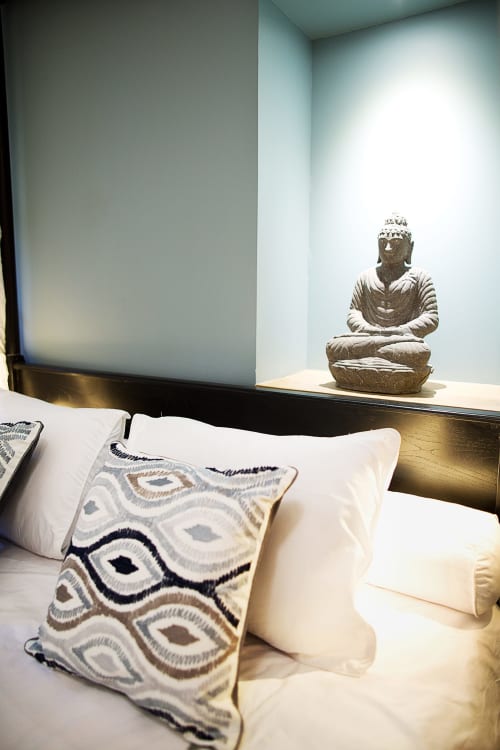 Luxurious VIP Lodge bedroom at AJOUCADOU Lourmarin with white bedding, patterned pillow, and Buddha statue