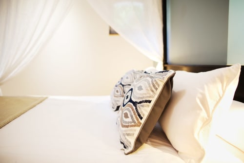 Luxurious bed with patterned throw pillow at AJOUCADOU VIP Lodge in Lourmarin, France