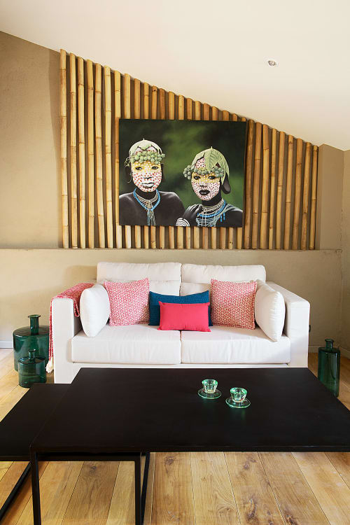 Modern living room at AJOUCADOU in Lourmarin with white sofa, wooden wall art, and tribal portrait above