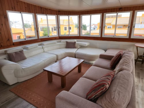Modern lounge area at Ocean View Lagos hostel with cream and taupe sectional seating, wooden coffee table, and panoramic