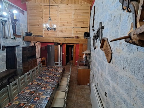 Comedor rústico en Apartamentos Turísticos Ávila con vigas de madera, mobiliario tradicional y vistas a la montaña