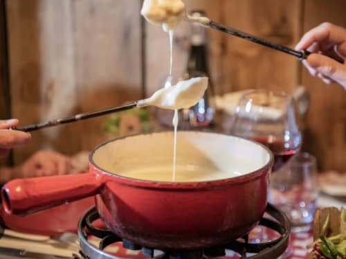 Fondue savoyarde traditionnelle à La Montagnette à Moutiers avec du fromage fondu trempé à la fourchette