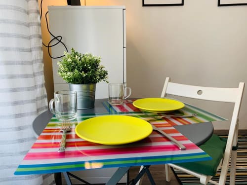 Colorful dining setup at Azur Studios Cannes with bright yellow plates and striped table runner