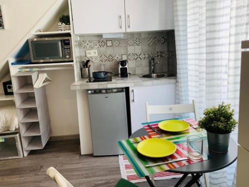 Superior Studio kitchenette with dining table at Azur Studios Cannes, featuring colorful dishware and compact kitchen