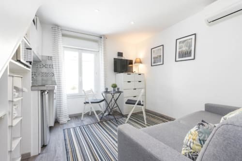 Superior Studio at Azur Studios Cannes featuring grey sofa, kitchenette, work desk, and modern furnishings