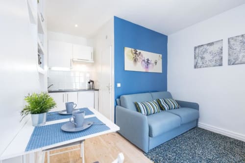 Superior Studio at Azur Studios Cannes with light blue sofa, blue accent wall, kitchenette, dining area, and modern