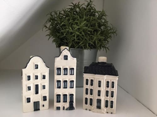 Decorative ceramic Dutch-style houses with black roof and windows beside potted plant in Azur Studios Cannes apartment
