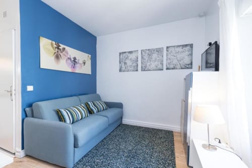 Superior Studio at Azur Studios Cannes with blue accent wall, sofa bed, sitting area, and modern amenities
