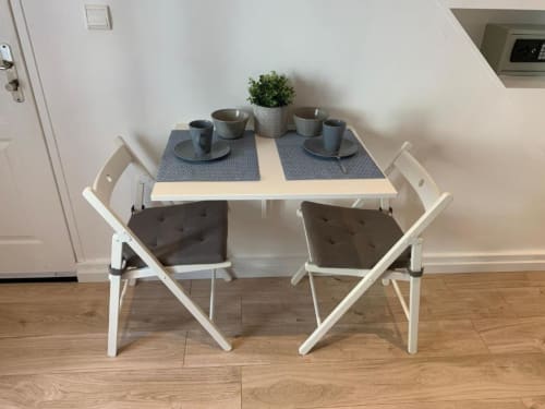 Dining table with two white chairs and place settings at Azur Studios Cannes Superior Studio apartment