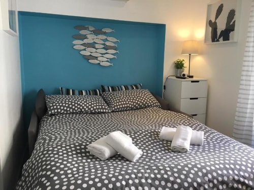 Modern Superior Studio bedroom at Azur Studios Cannes with turquoise accent wall, polka dot bedding, and fish wall art decor.
