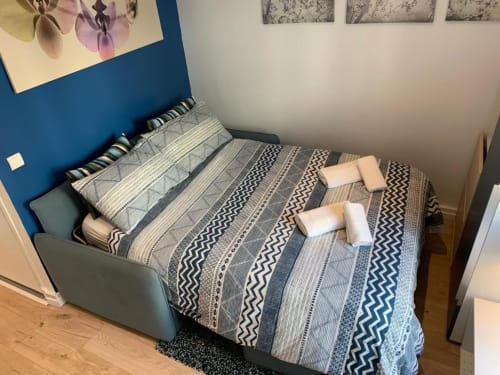 Modern bedroom at Azur Studios Cannes with geometric patterned bedding and blue accent wall