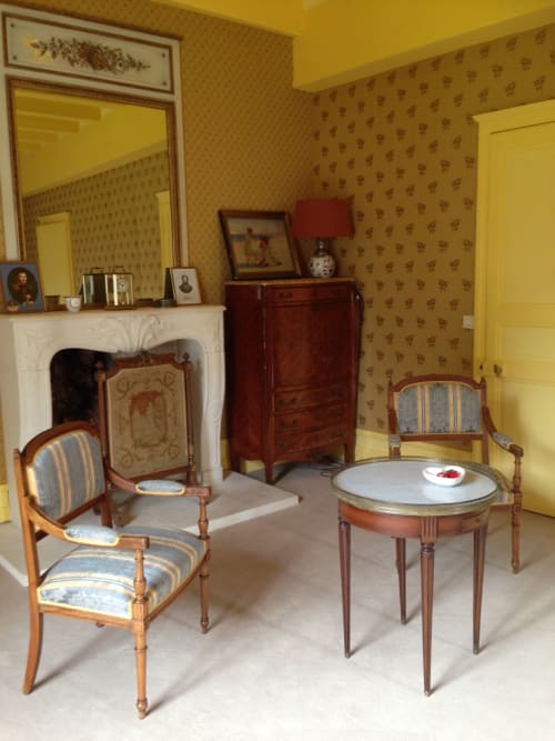 Chambre de Diane de Poitiers au Château de Ré avec mobilier d'époque, cheminée et papier peint à motifs jaunes au Petit