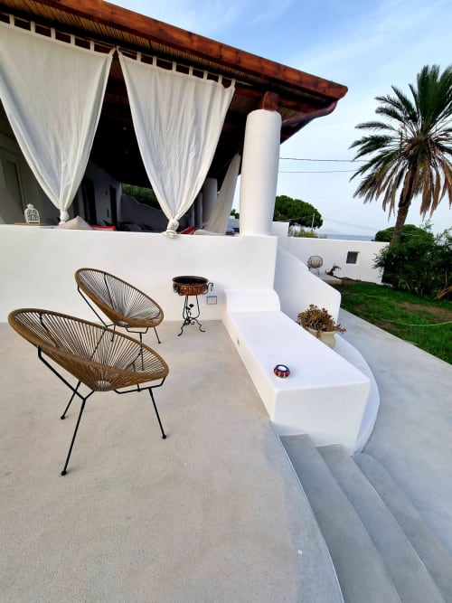 Miravilla Salina Terrasse mit geflochtenen Stühlen, weißen Vorhängen und Meerblick in Santa Marina Salina, Italien