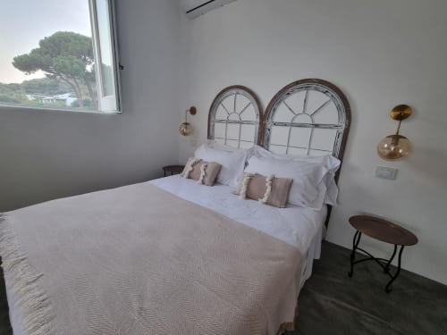 Helles Schlafzimmer im Miravilla Salina B&B in Salina mit Meerblick, Metallkopfteil, weißer Bettwäsche und modernen Pendelleuchten