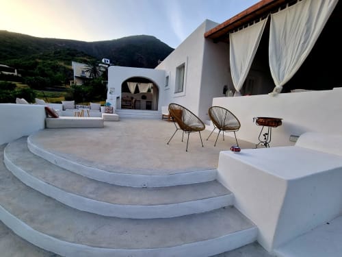 Miravilla Salina Terrasse mit geflochtenen Stühlen, weißen Liegestühlen und Bergblick in Santa Marina Salina