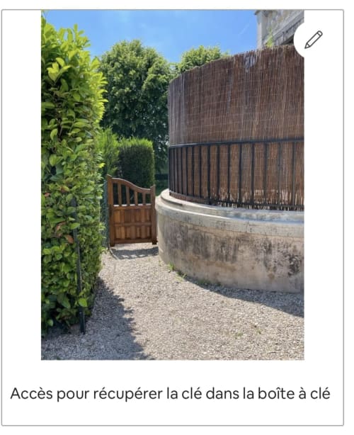 Portail en bois et allée gravillonnée menant à une clôture de roseaux foncés à Suite d'amour et détente à Chartrettes