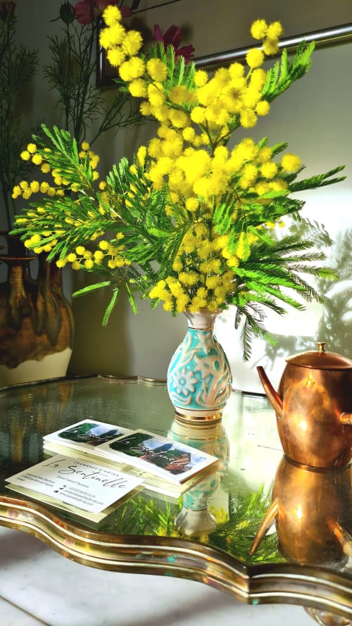 Bright yellow mimosa flowers in turquoise vase at La Sentinelle B&B, Les Arcs sur Argens