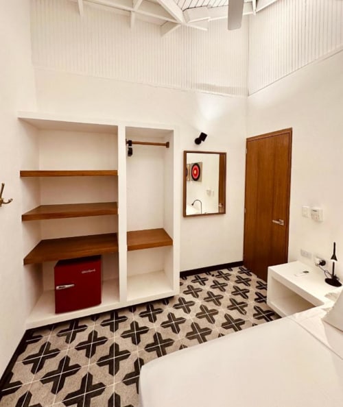 Baño moderno en el boutique lodge Seaflower con piso de azulejos geométricos, estantes de madera, minibar rojo y detalles de madera