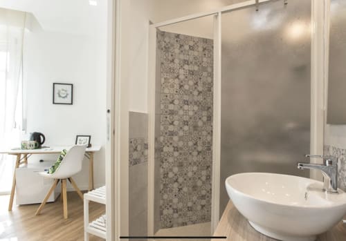 Modern bathroom at Catalogna10 Rooms e Loft in Alghero with walk-in shower, round white sink, and wooden vanity desk