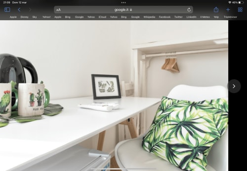 Modern double room at Catalogna10 in Alghero with white desk, plant décor, and tropical patterned cushions