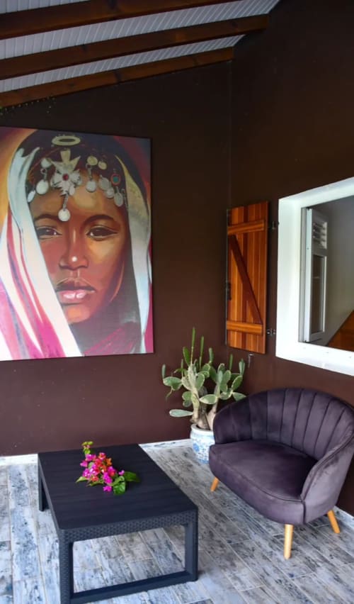 Coin salon moderne de la Villa Tourmaline avec art portraitiste coloré, plante succulente, chaise violette et bois foncé