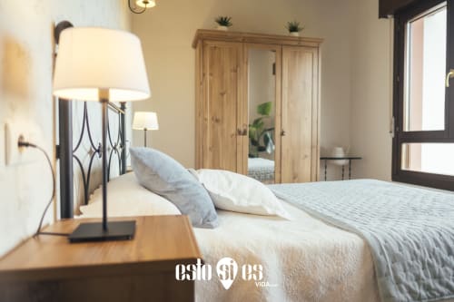 Modern bedroom at Esto si es vida in Ribadesella with garden view, wooden wardrobe, and bedside lamp