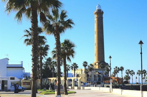 Faro de Chipiona y paseo arbolado con palmeras en el Hotel Bungalow Buda Beach, España