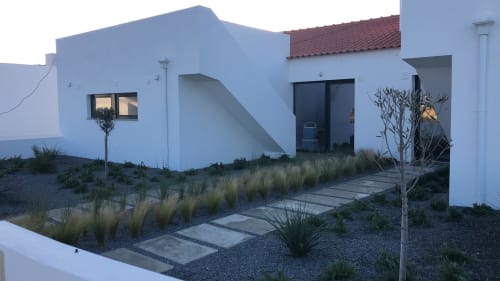Modern white house at Star Host Bordeira with gravel garden, ornamental grasses, and stepping stone pathway