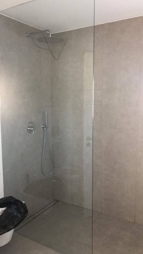 Modern shower enclosure with glass partition and rainfall showerhead at Star Host hotel in Bordeira, Portugal