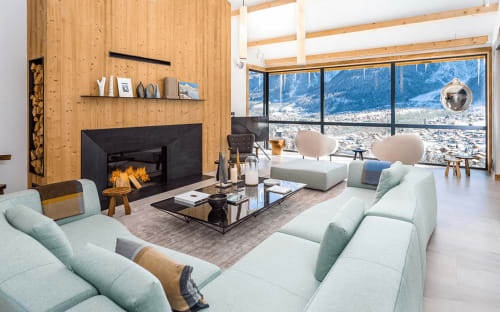 Salon alpin moderne avec cheminée, vue sur les montagnes et sièges menthe au Chalet Mont-Blanc, Chamonix
