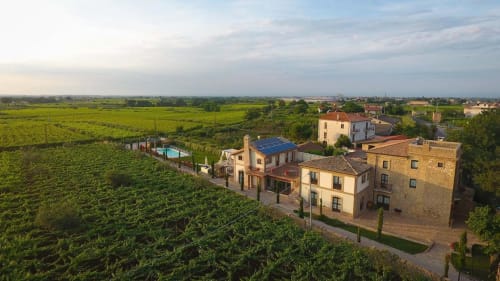 Casale 905 bed and breakfast in Crecchio, Italy, with terracotta buildings overlooking vineyards and countryside.