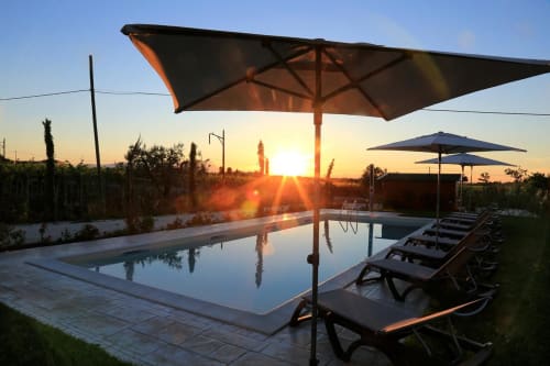Casale 905 pool at sunset with umbrellas and loungers overlooking Crecchio countryside