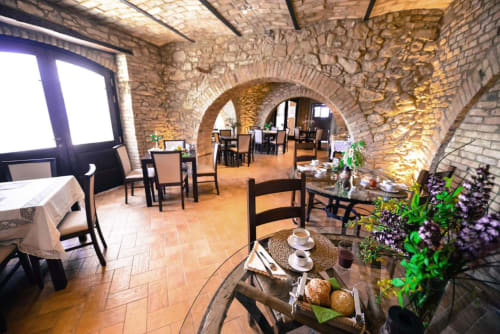 Rustic brick dining room at Casale 905 B&B in Crecchio with arched ceiling, terracotta floors, and elegantly set tables
