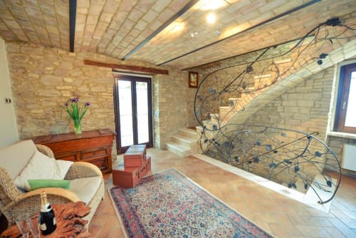 Casale 905 B&B living room in Crecchio with brick walls, wooden beams, staircase, and rustic furnishings