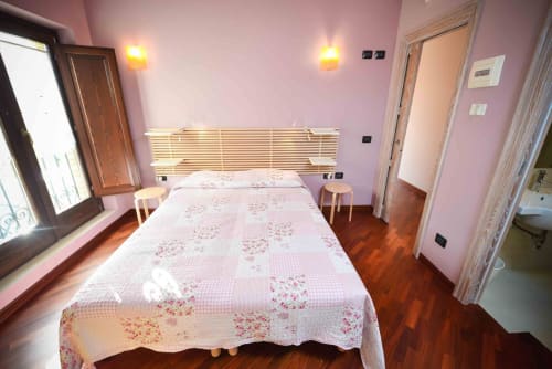 Bright pink bedroom with floral bedding at Casale 905 B&B in Crecchio, Italy