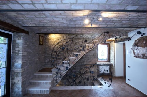 Casale 905 B&B stairwell in Crecchio with brick walls, wooden beams, ivy installation, and modern lighting