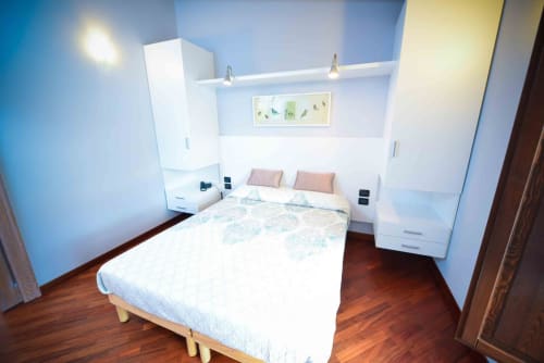 Modern bedroom at Casale 905 B&B in Crecchio with queen bed, white built-in storage, and hardwood floors