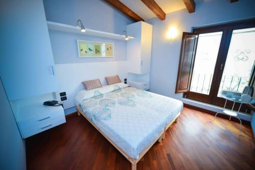 Modern blue bedroom at Casale 905 B&B in Crecchio with queen bed, wooden beams, and terrace access