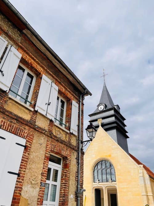 Clairseine B&B in Tournedos-sur-Seine with historic brick building and church bell tower