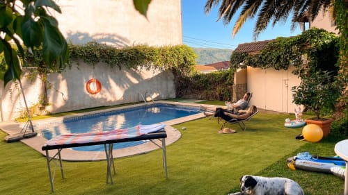 Jardín trasero de Villa del Jerte con piscina, cama elástica, tumbonas y vistas a la sierra en El Torno, Cáceres