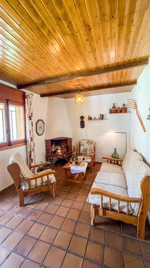 Sala rústica en Casa Rural Villa del Jerte con techo de madera, chimenea y muebles tradicionales